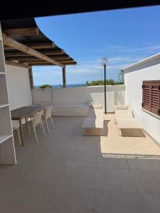 a patio with a table and chairs and the ocean at Almaré Luxury Beach Apartments in Taranto