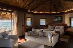 a bedroom with a bed and a couch at Le Tikehau by Pearl Resorts in Tikehau
