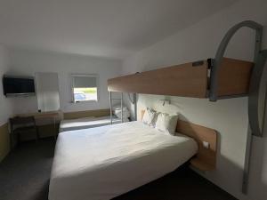a bedroom with two beds and a bunk bed at Ibis Budget Ancenis in Mésanger