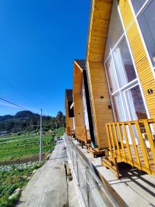 a wooden house with benches on the porch at Villa Celyn Dieng cabin in Diyeng