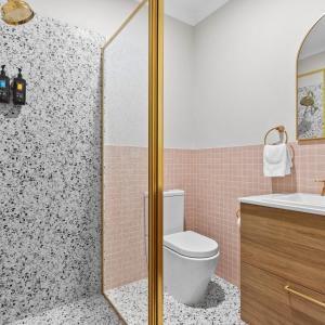 a bathroom with a shower with a toilet and a sink at Tocumwal Hotel Motel in Tocumwal