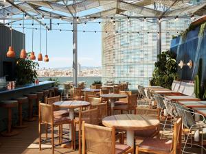 a restaurant with tables and chairs and a view of the city at The Hoxton, Poblenou in Barcelona