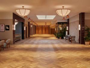 an empty lobby with wooden floors and lights at The Hoxton, Poblenou in Barcelona +149 photos
