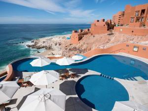a view of a pool with umbrellas and the ocean at Club Regina Los Cabos in San José del Cabo +114 photos