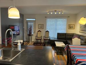 Eine Küche und ein Wohnzimmer mit Sofa und Spüle in der Unterkunft Le 2316 in Saint-Hyacinthe