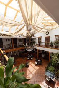 a large room with a large glass ceiling with tables at Hotel & Suites El Quijote in Cuenca