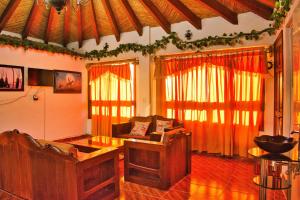 a living room with a couch and some windows at Finca del Valle in Valle de Bravo
