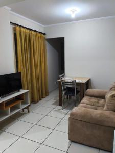 a living room with a couch and a table at Apartamento central 1 quarto in Passo Fundo