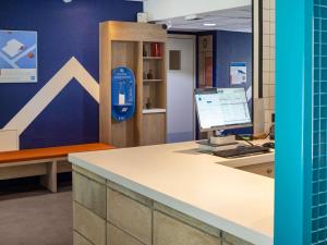 an office with a desk with a computer on it at ibis budget Bourg en Bresse in Bourg-en-Bresse