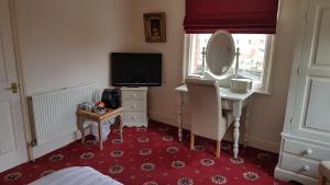 a bedroom with a dressing table and a mirror at Lil's On The Waterfront in York