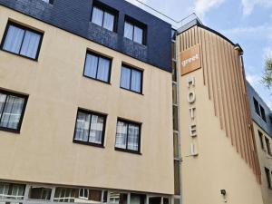 a building with a sign on the side of it at Greet Hotel Evreux Centre - Route de Normandie by Accor in Évreux