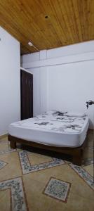 a white bed in a room with a wooden ceiling at Apartamento Brisa y Mar 2 in Arboletes