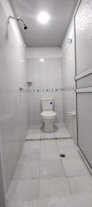 a white bathroom with a toilet in a room at Apartamento Brisa y Mar 2 in Arboletes