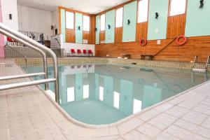 a large swimming pool in a building at Confederation Inn Saskatoon in Saskatoon
