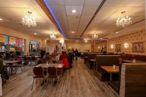a dining room with people sitting at tables in a restaurant at Confederation Inn Saskatoon in Saskatoon