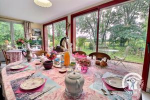 a dining room with a table with a pink table cloth at Le moulin de blochet in Saint-Erblon +36 photos
