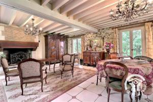a dining room with a table and chairs and a fireplace at Le moulin de blochet in Saint-Erblon