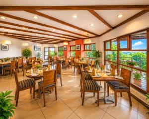 a restaurant with tables and chairs and windows at Sterling Yercaud in Yercaud