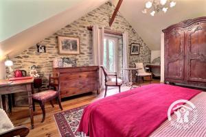 a bedroom with a bed and a table and chairs at Le moulin de blochet in Saint-Erblon