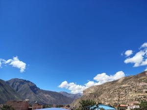 a view of mountains and a blue sky with clouds at hostal Balcon de Piedra in Urubamba