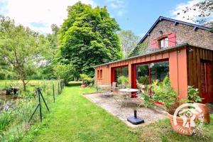 a red cottage with a table and chairs in the yard at Le moulin de blochet in Saint-Erblon