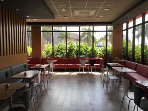 a restaurant with tables and chairs and large windows at ibis Jatai Shopping in Jataí