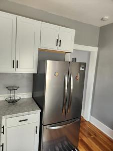 a kitchen with a stainless steel refrigerator and white cabinets at Peabody short term rental in Staunton