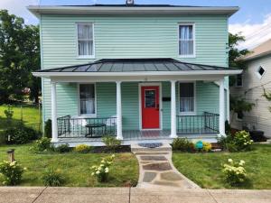 a green house with a red door at Peabody short term rental in Staunton