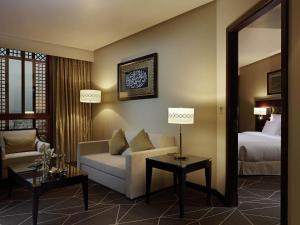 a living room with a couch and a bed at Zamzam Pullman Madina in Medina