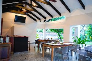 a dining room with tables and chairs and windows at Mopani Lodge Victoria Falls in Victoria Falls