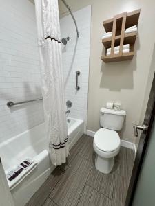 a bathroom with a toilet and a tub and a shower at Granada Inn in Granada Hills +17 photos