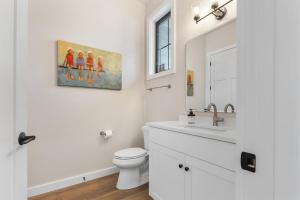 a white bathroom with a toilet and a sink at La Dolce Vita in Egg Harbor