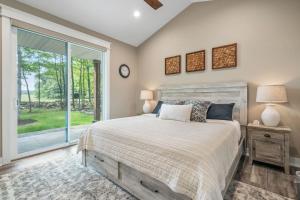 a bedroom with a bed and a large window at Stonehedge View by Simple Life Rentals in Egg Harbor