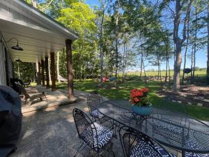 a patio with a table and chairs on a porch at Stonehedge View by Simple Life Rentals in Egg Harbor