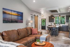 a living room with a brown couch and a kitchen at Stonehedge View by Simple Life Rentals in Egg Harbor
