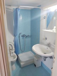 a bathroom with a toilet and a shower and a sink at Zoumboulis Rooms in Mytilene