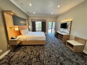 a large hotel room with a bed and a television at Granada Inn in Granada Hills