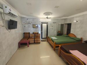a bedroom with two beds and a tv in a room at SEYONE stay in Kanchipuram