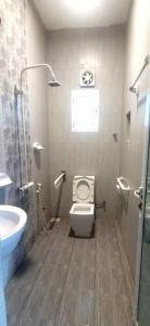 a bathroom with a toilet and a sink at شاليه السكون AL Sukun Chalet in Al Ḩadd +12 photos