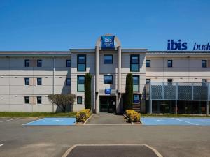 a building with a parking lot in front of it at ibis budget Albi Terssac in Terssac