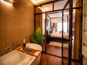 a bathroom with a bath tub and a bedroom at Casa Dives - Varianta Boierească in Pianu de Sus