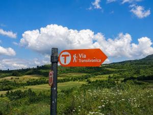 a red sign on a pole in a field at Casa Dives - Varianta Boierească in Pianu de Sus