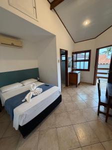 a bedroom with a bed with a white flower on it at Cantinho Centro Histórico in Paraty