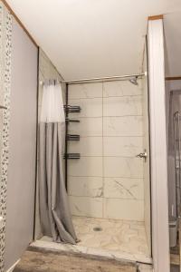 a shower with a shower curtain in a bathroom at The Hidden Creek Hideaway in Huntsville +56 photos
