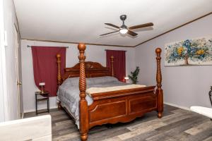 a bedroom with a wooden bed and a ceiling fan at The Hidden Creek Hideaway in Huntsville