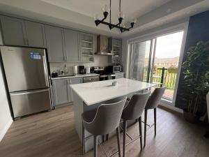 a kitchen with a white counter and chairs in it at Oakville Townhouse Amazing Rooftop in Oakville