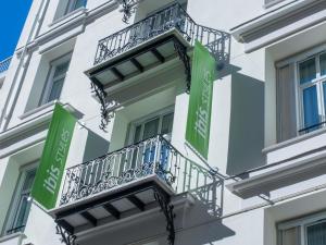 a building with green and white balconies on it at Ibis Styles Nice Centre Gare in Nice