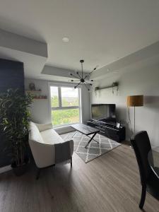 a living room with a white couch and a tv at Oakville Townhouse Amazing Rooftop in Oakville
