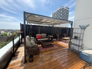 a deck with a couch and a table on a balcony at Oakville Townhouse Amazing Rooftop in Oakville