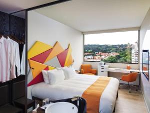 a hotel room with a large bed and a window at Ibis Styles Singapore On Macpherson in Singapore +110 photos